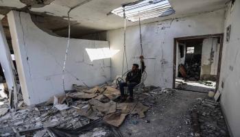 رجل في أرجوحة في منزله الذي دمره قصف إسرائيلي في خانيونس جنوبيّ قطاع غزّة في 30/ 11/ 2023 (Getty)