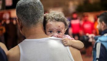 أب يحمل ابنته المذعورة بعد قصف إسرائيلي على خانيونس جنوبي غزة، 17 تشرين الأوّل/ أكتوبر 2023 (Getty)