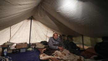 رجل فلسطيني يجلس داخل خيمة في مخيم للنازحين في رفح جنوب قطاع غزّة في 13/ 12/ 2023 (فرانس برس)