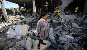 يقفون فوق ركام مبانٍ مدمرة بسبب قصف إسرائيلي في بلدة الزوايدة وسط قطاع غزّة في 10/ 12/ 2023 (Getty)