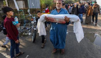 يحمل جثمان شهيد استشهد بسبب قصف إسرائيلي في خان يونس جنوبيّ قطاع غزّة في 6/ 12/ 2023 (Getty)