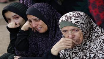  نساء فلسطينيات يبكين أقارب لهن استشهدوا بسبب قصف إسرائيلي في مستشفى في دير البلح وسط قطاع غزّة في 6 / 12/ 2023 (الأناضول)