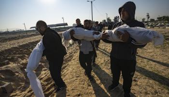 فلسطينيون وجثث شهداء في قطاع غزة (فاطمة شبير/ أسوشييتد برس)