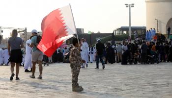 طفل يحمل العلم القطري في الدوحة، 18 ديسمبر 2022 (Getty)