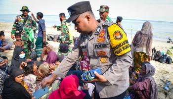 لاجئون روهينغا وشرطة في إندونيسيا (جوني سابوترا/ فرانس برس)