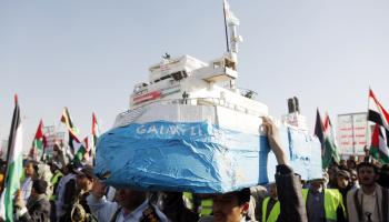 متظاهر يمني يحمل نموذج لسفينة الشحن الإسرائيلية جالاكسي ليدر التي احتجزها الحوثيين (محمد حمود/Getty)