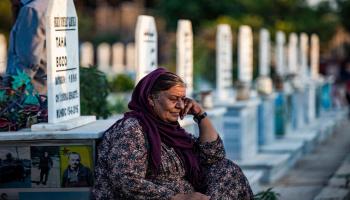 امرأة في مقبرة خلال تشييع أحد مقاتلي قوات سورية الديمقراطية في مدينة القامشلي شمال شرق سورية في 10/ 8/ 2022 (فرانس برس)