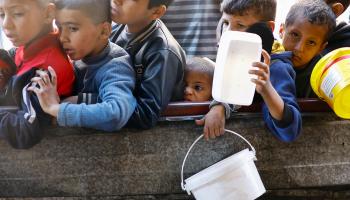 أطفال فلسطينيون ينتظرون الحصول على الطعام (رويترز/إبراهيم أبو مصطفى)