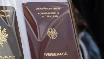 جواز سفر ألماني إلى جانب جواز سفر فرنسي (فرانسوا موري/ أسوشييتد برس)