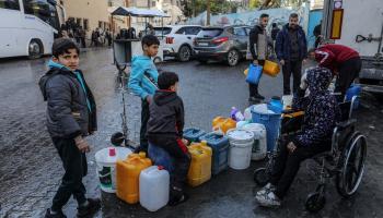 أطفال فلسطينيون ينتظرون قي صفوف للحصول على مياه الشرب في رفح (getty)