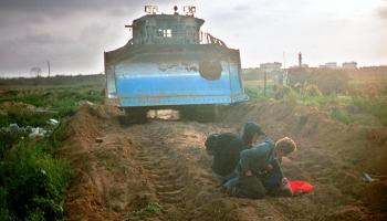 راشيل كوري مُمدّدة على الأرض بعدما دهستها جرّافة الاحتلال، رفح، 16 آذار/ مارس 2003 (Getty)