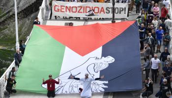 محتجّون يرفعون علم فلسطين يصوّر لوحة غيرنيكا لبيكاسو، سان سيباستيان شمال إسبانيا، 17 آذار/ مارس 2024 (Getty)