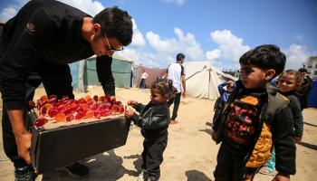 يقدم حلوى لصغار في دير البلح (مجدي فتحي/ Getty)