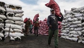 عمال مصريون يحملون أكياس فحم في 17 ديسمبر 2023 (Getty) 
