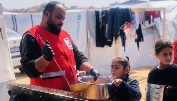 أطفال فلسطينيون ووجبات غذائية في مخيم نازحين في مدينة غزة - 6 إبريل 2024 (الأناضول)