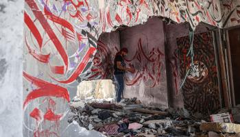 الفنان أيمن الحصري يُنجز جدارية على بيت في بيت لاهيا، 17 حزيران/ يونيو 2023 (Getty)