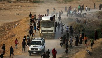 فلسطينيون يلاحقون شاحنة تحمل مساعدات وصلت عبر الرصيف البحري (مجدي فتحي/Getty)