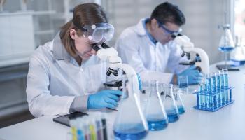 باحثان يقومان بفحص جيني داخل مختبر، في 2023 (Getty)