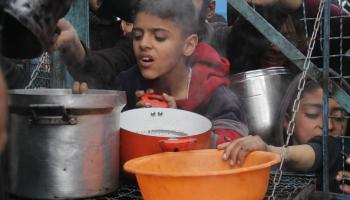 يأمل النازحون في الحصول على حساء مجاني في مخيم جباليا (محمود عيسى/الأناضول)