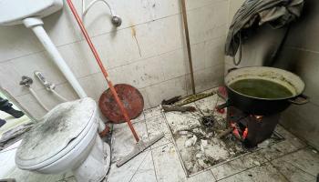 أسرة الغندور النازحة من شمال غزة تستخدم الحمام كمطبخ في آن واحد (الأناضول)