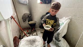 أسرة الغندور النازحة من شمال غزة تستخدم الحمام كمطبخ في آن واحد (الأناضول)