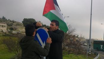 نشطاء يعلقون الأعلام الفلسطينية على مداخل المستوطنات جنوب الضفة