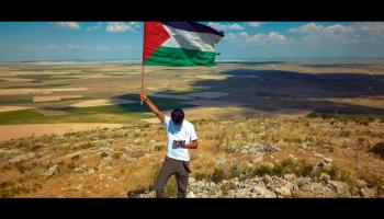 بنجامين لادرا رافعاً علم فلسطين (العربي)