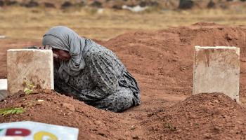 والدة مقاتل كردي من كوباني تبكي على قبره(فرانس برس)