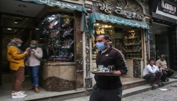 مصريون يضعون الكمامات في شارع المعز بالقاهرة (Getty)