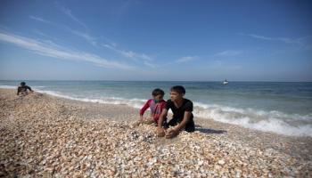 أطفال فلطسنينيون يلهون على شاطىء غزة