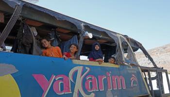 عائلة سورية تعيش داخل حافلة مدمرة (زين الرفاعي/فرانس برس)