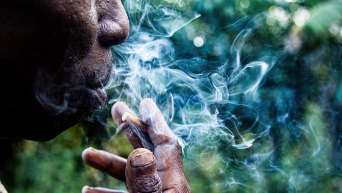 كيني يدخن سيجارته في الهواء الطلق (جايمس واكيبيا/ Getty)