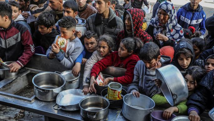 ينتظرون بعض الطعام في غزة (عبد الرحيم الخطيب/الأناضول)