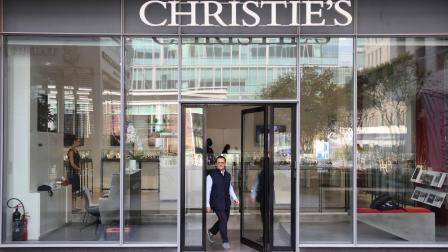 موظف أمام مدخل "كريستيز" في دبي، 25 مارس 2022 (كريم صاحب/ فرانس برس)