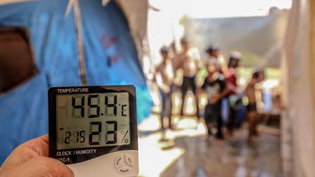 أطفال بمخيم في إدلب يحاولون تبريد أنفسهم بالمياه، في 16 أغسطس 2023 (الأناضول)