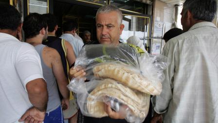 Tyre, LEBANON: Lebanese men buy stocks of bread in the southern Lebanese city of Tyre, 18 July 2006. Israeli jets pounded Lebanon with a blistering wave of deadly raids under the cover of darkness on today, the seventh day of an assault that has sent tens of thousands of people fleeing for their lives. AFP PHOTO/HASSAN AMMAR (Photo credit should read HASSAN AMMAR/AFP via Getty Images)