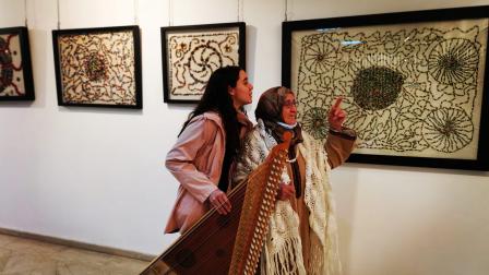 الفنانة مع حفيدتها التي قدمت عزفاً على آلة القانون في افتتاح المعرض