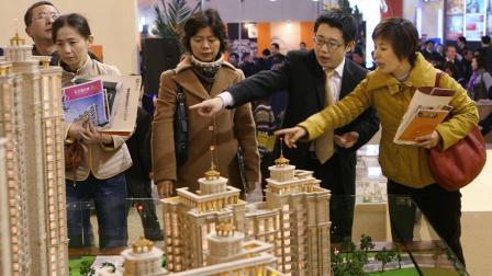 Shanghai, CHINA: Chinese investors talk with a property salesman for a new housing development at a real estate exhibition in Shanghai, 16 March 2007. China's parliament overwhelmingly approved a property law that has sparked controversy by offering unprecedented protection to the private sector. The legislation had been through a record 13 years of debate, passed seven readings and been the subject of criticism and proposals from 47 government departments and an unprecedented 11,500 members of the public. 