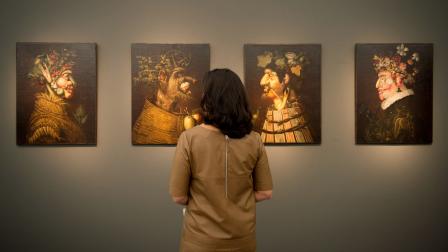زائرة أمام سلسلة "الفصول الأربعة" لـ أرشيمبولدو، خلال معرض بلندن، تشرين الأول 2013 (Getty)