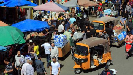 عراقيون في سوق في العراق (مرتضى السوداني/ الأناضول)