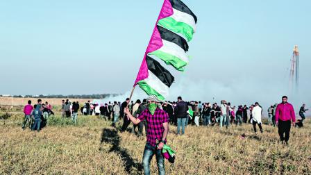 رفع العلم الفلسطيني في خان يونس (يوسف مسعود/Getty)