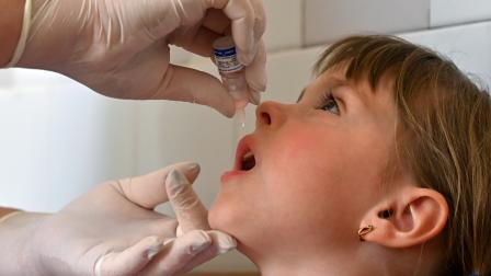 طفلة تحصل على اللقاح المضاد لشلل الأطفال (سيرغي سوبينسكي/ فرانس برس)