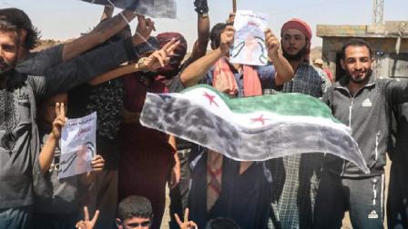 رفع المتظاهرون في بلدة العزبة أمس أعالم الثورة السورية (العربي الجديد)