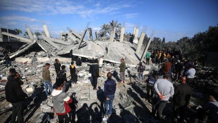 فلسطينيّون أمام عمارتهم التي دمّرها العدوان