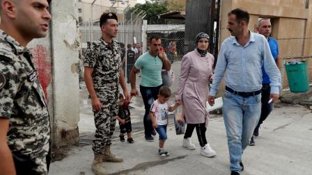 لاجئون سوريون وقوات أمن لبنانية في منطقة برج حمود (أنور عمرو/ فرانس برس)
