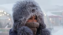 يغطي سكان المدينة وجوههم للحماية من البرد (يفجيني سوفورنييف/تاس)