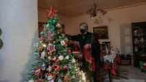 مسيحية فلسطينية تزين شجرة الميلاد بمنزلها في غزة (عبد الحكيم أبو رياش) 