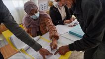 التوقيع على سجل بعد التصويت في الانتخابات المحلية الجزائرية في مركز اقتراع بالعاصمة الجزائر (رياض كرامدي/فرانس برس)