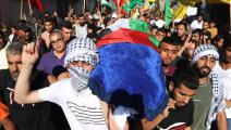 شارك مئات الفلسطينيين ببلدة إذنا في تشييع جثمان الشهيدة (مأمون وزواز/الأناضول)