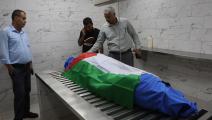 وضع علم فلسطين على جثمان الشهيدة في غرفة الغسل (مأمون وزواز/الأناضول)